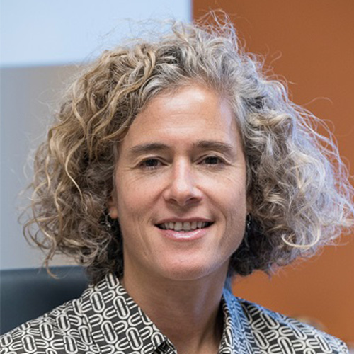 Headshot of Fermi researcher Keren Bergman. She smiles and wears a patterned button up. She sits in an office.